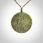 This piece is a contemporary disc pendant hand carved in New Zealand jade.