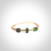 Hand carved New Zealand jade adjustable bracelet with beige cord. Carved in New Zealand jade by Ric Moor for NZ Pacific. One only armband for women and men.
