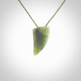 This is a lovely New Zealand Jade, pounamu niho drop pendant. It is bound with an adjustable khaki coloured cord which is length adjustable.