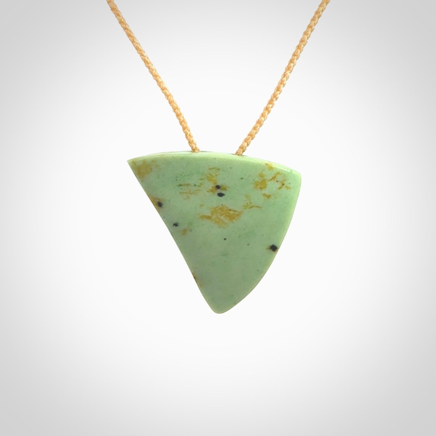 This is a lovely New Zealand Jade, pounamu niho drop pendant. It is bound with an adjustable beige coloured cord which is length adjustable.