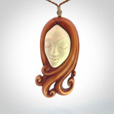 This is a hand carved bone contemporary female pendant. Yuri Terenyi has carved this from Stained Bone with Woolly Mammoth Tusk and Paua Shell inlay on the back of the pendant. It is a delightful, large and artistic piece of jewellery. One only necklace. The necklace is provided on an adjustable cord in a hand made, custom, wooden box.