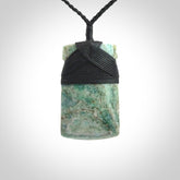 This is a handcrafted aotea stone Toki pendant.