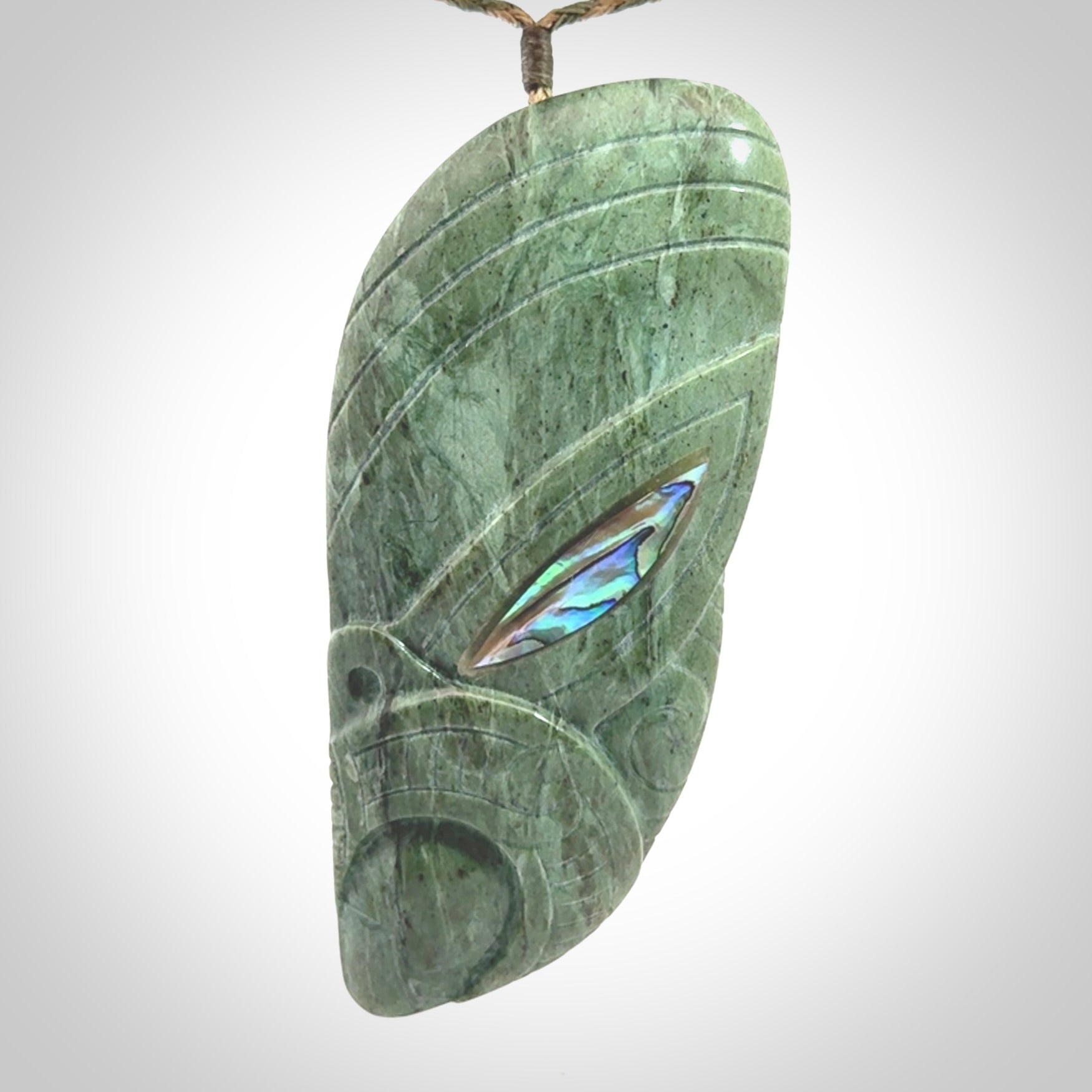 This is a hand carved New Zealand Jade wheku pendant. It is made from New Zealand Jade and Paua shell.