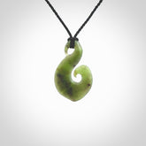 This koru/matau, is carved from a very striking New Zealand jade. It is both intricate and simple in design - it has hidden folds and smooth curves. A piece to be worn, the carving and the jade are both magnificent.