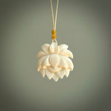 This is a hand carved lotus flower pendant. It is made from bone. This is a medium sized necklace and is a very unique, pendant that is a collectors piece. Hand carved bone lotus flower necklace.