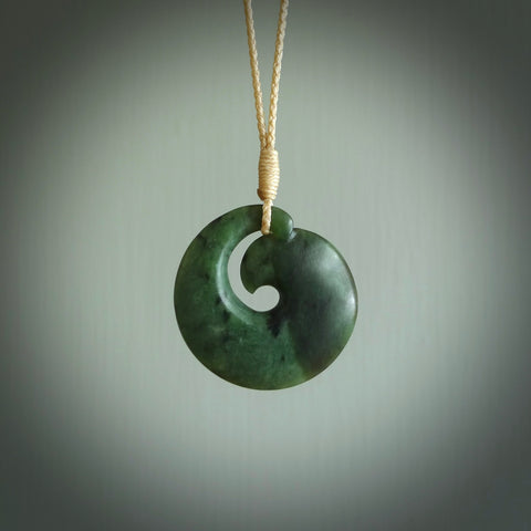This picture shows a koru pendant, hand carved from New Zealand jade. We will provide this with an adjustable plaited cord. This has been hand carved by Kyohei Noguchi. One only pendant, shipped to you with express courier.