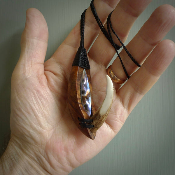 This picture shows a large matau, hook called a pā kahawai. It is carved from deer antler bone, wood, and paua shell. One only, free shipping worldwide. Provided with an adjustable black cord. Stunning work of Art to Wear by Fumio Noguchi.