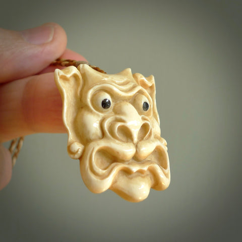 Hand carved incredible stained bone gargoyle face carving. A stunning work of art. This pendant was hand carved in bone with buffalo horn inlay for the eyes by Yuri Terenyi. A one off collectors item that has been hand crafted to be worn or displayed.