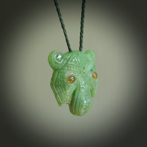 This picture shows a tiger pendant that we designed in Jade stone with Amber inlay eyes. It is a tiger head that is carved in detail. A really attractive and eye-catching piece of handmade jewellery. The cord is hand plaited braid in green and the length can be adjusted.