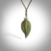 This picture shows a leaf shaped pendant, hand carved from New Zealand flower jade. It has a silver cap with loop on the top for a cord or a chain. We will provide this with an adjustable plaited cord.