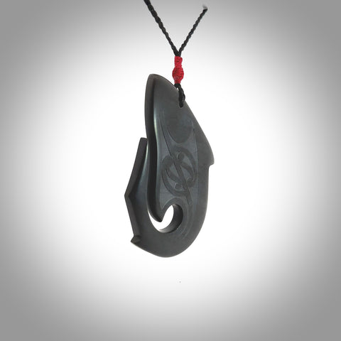 Hand carved New Zealand Argillite Stone shark pendant by Rueben Tipene. Hand made art to wear for lovers of the ocean. Delivered with express courier and delivered to you on an adjustable cord.