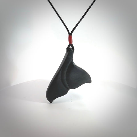 Hand carved New Zealand Argillite Stone whale tail pendant by Rueben Tipene. Hand made art to wear for lovers of the ocean. Delivered with express courier and delivered to you on an adjustable cord.