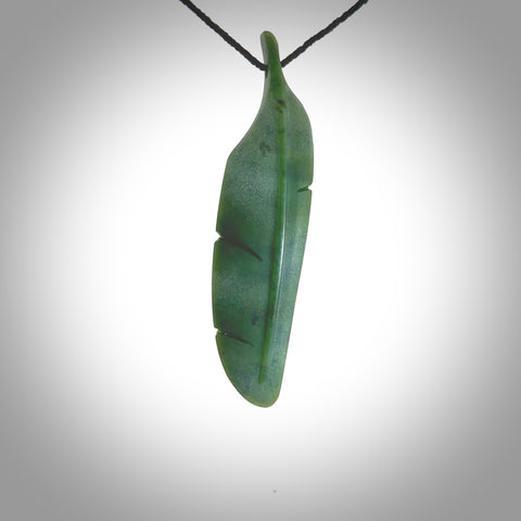 A hand carved large New Zealand Jade feather necklace. The cord is a black colour and is a fixed length. A large sized hand made Jade feather necklace by New Zealand artist Kerry Thompson. One off work of art to wear.