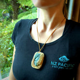 A photo of a New Zealand whale bone, Aotea Stone, ruby and sapphire face pendant. This is a one off, statement piece - hand crafted here in New Zealand by Jeremy. Unique Art to Wear. Gifts for all lovers of hand made Art to Wear. One only collectors pendant. Delivery is free worldwide. Included is a wooden box