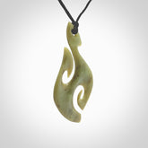 This photo shows a koru pendant carved from New Zealand Jade. The artist, Shaun Gardiner, has carved this beautifully. We provide this piece with an adjustable black cord. This is a fantastic work of art, we have one only.