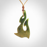 This photo shows a hook pendant carved from New Zealand Flower Jade. The artist, Shaun Gardiner, has carved this beautifully. We provide this piece with an adjustable Kalahari cord. This is a fantastic work of art, we have one only.