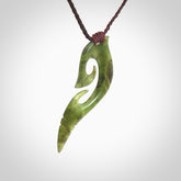 This photo shows a koru pendant carved from New Zealand Jade. The artist, Shaun Gardiner, has carved this beautifully. We provide this piece with an adjustable brown cord. This is a fantastic work of art, we have one only.