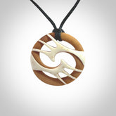 A hand carved bone contemporary, intricate pendant. The cord is a black colour and is a fixed length. A medium sized hand made contemporary necklace by New Zealand artist Kerry Thompson. Kerry has stained parts of the bone which really add to the dimension of this pendant. One off work of art to wear.