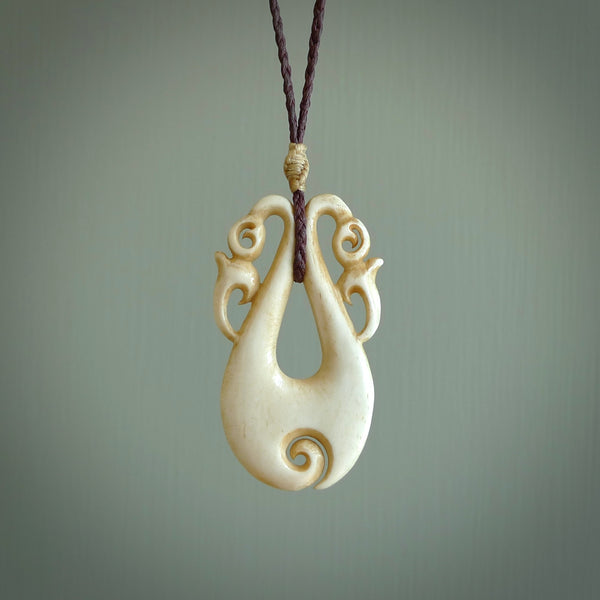 This is a unique double manaia with koru, hand carved stained bone pendant with. The bone is a brown honey colour which has been stained using a homemade dye. The cord is Black and is length adjustable. This is delivered to you with Express Courier.
