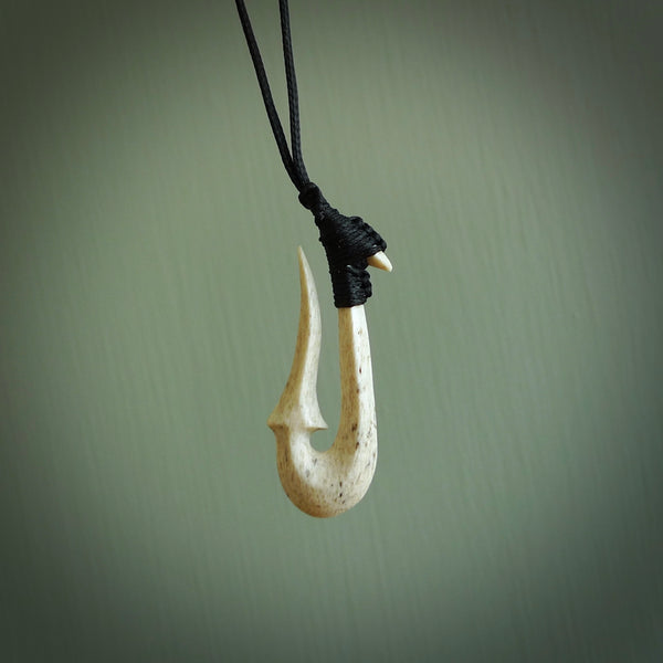 Hand made whale bone hook, or matau, pendant carved from a piece of whalebone. The cord can be adjusted. It is a large sized pendant and is well carved. A beautiful piece of art to wear, hand carved jewellery. Delivered in woven kete pouch with express courier.