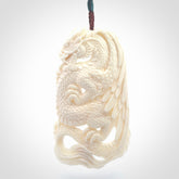 This is a hand carved bone dragon pendant. It is made from bone and has an adjustable Plum coloured cord. This is a large sized necklace and is a very unique, one only, pendant that is a piece for art lovers.