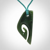 This photo shows a koru pendant carved from New Zealand Jade. We provide this piece with an adjustable blue cord.