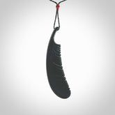 A hand carved large Wyoming Black Jade feather necklace. The cord is a black colour and is an adjustable length. A large sized hand made Black Jade feather necklace by New Zealand artist Kerry Thompson. One off work of art to wear.