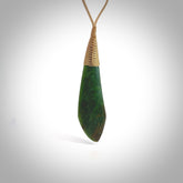 This photo shows a beautiful large jade drop. It is handcarved from a piece of green New Zealand pounamu, with fascinating light green inclusions throughout the stone. We have this on a creme coloured, adjustable four plait cord. We ship this worldwide with an express courier service. Postage is free.