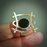 This is a handcrafted New Zealand Pounamu, Jade and sterling silver ring. This is a solid little work of art. We ship this worldwide for free and are happy to answer any questions that you may have about these or other products on our website. Hand carved by Ana Krakosky. Delivered with Express Courier in a woven kete pouch.