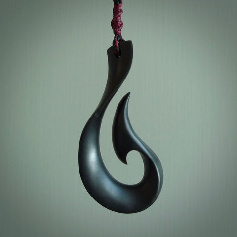 A hand carved large Black Jade Hook, Matau, necklace. The cord is a black colour and is a fixed length. A large sized hand made hook necklace by New Zealand artist Kerry Thompson. One off work of art to wear.