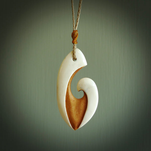 A hand carved bone contemporary, intricate pendant. The cord is tan colour and is adjustable. A medium sized hand made contemporary necklace by New Zealand artist Tonijae Brockway. Tonijae has stained parts of the bone which really add to the dimension of this pendant. One off work of art to wear.