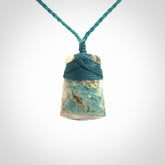 This is a handcrafted aotea stone Toki pendant.