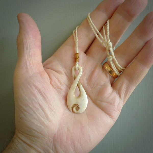 Hand carved Single twist pendant with a little koru carved into the bottom. This pendant is carved from a lovely cream coloured bone. The artist is Yuri Terenyi. Bone art to wear by NZ Pacific.