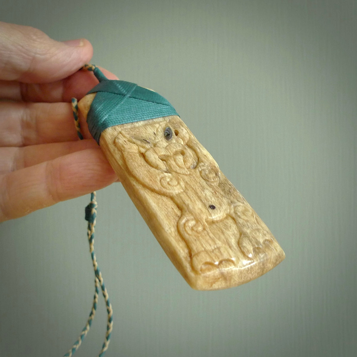HAND CARVED BONE TOKI WITH TIKI PENDANT. BONE TOKI WITH TIKI PENDANT