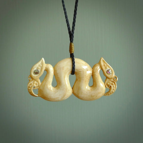 This is a unique double manaia, pekapeka, handcarved bone pendant from cow bone. The cord is Black and is length adjustable. This is delivered to you with Express Courier. The eyes are made from Paua shell.