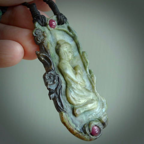 A photo of a New Zealand Jade praying pendant with . This is a one off, statement piece - hand crafted here in New Zealand by Jeremy. Unique Art to Wear. Gifts for all lovers of hand made Art to Wear. One only collectors pendant. Delivery is free worldwide. Included is a wooden box.