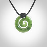 Hand carved British Columbian jade koru pendant. Delivered to you on a hand plaited black cord which is adjustable. Free delivery worldwide.
