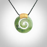Hand carved British Columbian jade koru pendant. Delivered to you on a hand plaited manuka green cord which is adjustable. Free delivery worldwide.