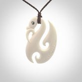 Hand carved bone manaia pendant with paua shell eye inlay. Hand made bone pendant.