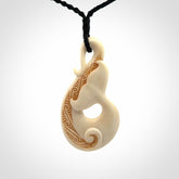 Hand carved Bone Whale Tail pendant by Andrew Doughty. Whale tail pendant by Andrew Doughty with engraving in it. Beautiful unisex necklace hand carved in New Zealand, delivered in a woven kete pouch. Provided with an adjustable beige cord.