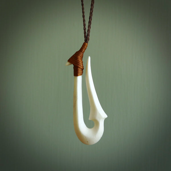 Hand made whale bone hook, or matau, pendant carved from a piece of whalebone. The cord can be adjusted. It is a large sized pendant and is well carved. A beautiful piece of art to wear, hand carved jewellery. Delivered in woven kete pouch with express courier.