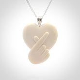 This is a hand carved love heart with love fingers made from bone with sterling silver bale and provided with a sterling silver chain.