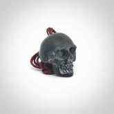 This picture shows a Black Obsidian stone skull pendant that we have hand carved. It is polished to a soft shine and is a very striking piece. Provided with an adjustable plum cord.