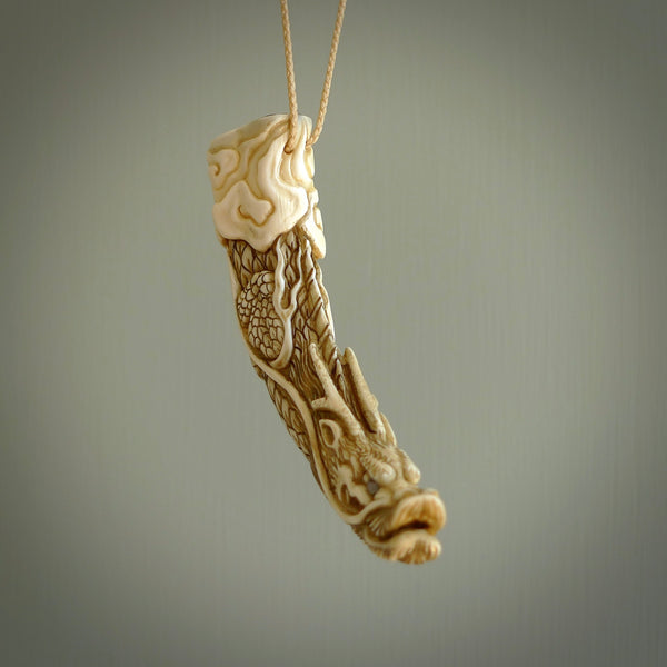 Hand carved dragon Pendant. Made from warthog tusk in New Zealand. Unique dragon necklace hand made from warthog tusk by master bone carver Fumio Noguchi. Spectacular collectable work of art, made to wear. One only pendant, delivered to you at no extra cost with express courier.