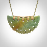 Hand carved New Zealand Flower Jade half-shield pendant.