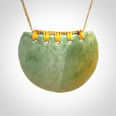 Hand carved New Zealand Flower Jade half-shield pendant.