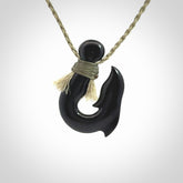 These pendants are hand carved, black jade hooks or matau pendants. They are beautifully finished in a high polish and bound with a khaki necklace cord.