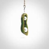 Hand carved New Zealand Marsden Jade two peas in a pod drop pendant with two pearl inlays. Made by Ana Krakosky for NZ Pacific in New Zealand Pounamu, flower jade with real pearls. A beautiful dark green and orange jade representing two peas in a pod. A drop with pearl inserts necklace with long sterling silver chain. One only, provided in a wooden gift box and delivered with express courier.