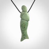Hand carved New Zealand Jade woman drop pendant. Made by Ana Krakosky for NZ Pacific in New Zealand Pounamu, jade. A beautiful light green jade figure of a woman, drop necklace with black adjustable cord.