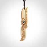 This picture shows a carved hawk in bone. It is a drop shaped pendant. The artist has carved traditional decorative kowhaiwhai designs into the body and these run up the sides of the hawk. These have specific meanings. It is provided with a hand-plaited brown cord that is length adjustable. Shipping is included and we ship worldwide.